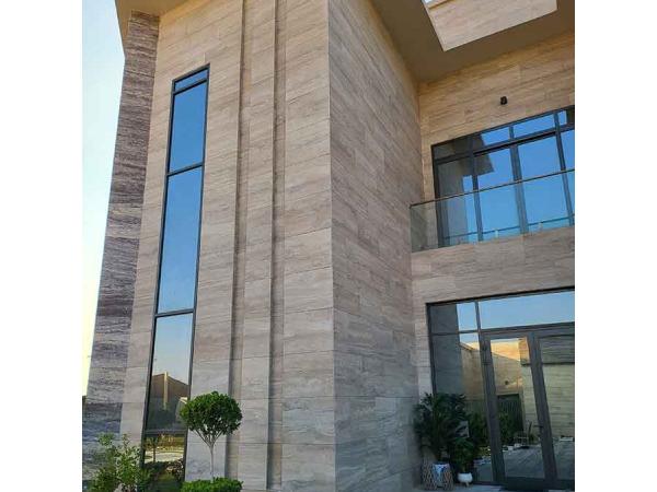 Elewacja zewnętrzna z płytek trawertynowych w jasnym kolorze